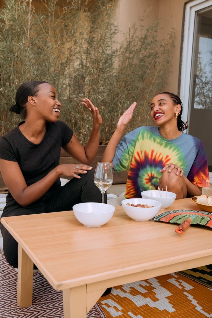 Women Sitting at a Table and Smiling