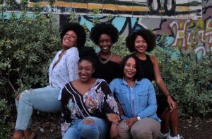 five woman sitting on the ground